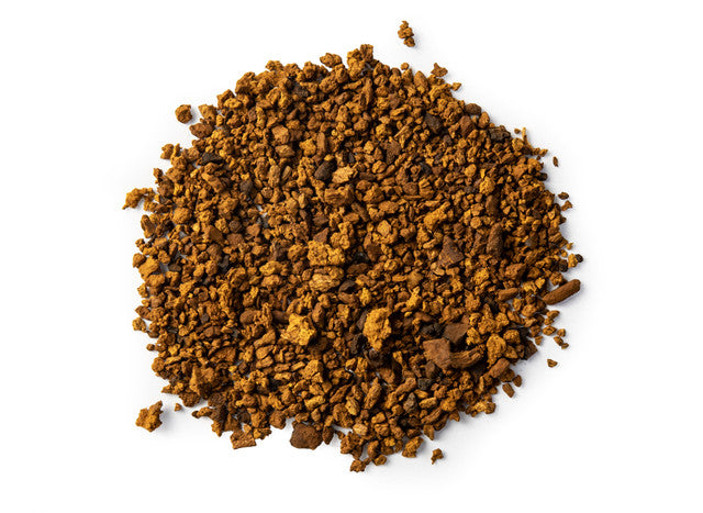 Top-down view of organic chaga mushroom powder by Healing Herbals, featuring coarse, earthy brown granules on a clean white background.