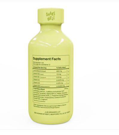 Back view of a pale yellow Jubi Lion’s Mane supplement shot bottle showing the Supplement Facts panel, ingredient list, and “Shake Well” text on the cap, displayed on a white background.