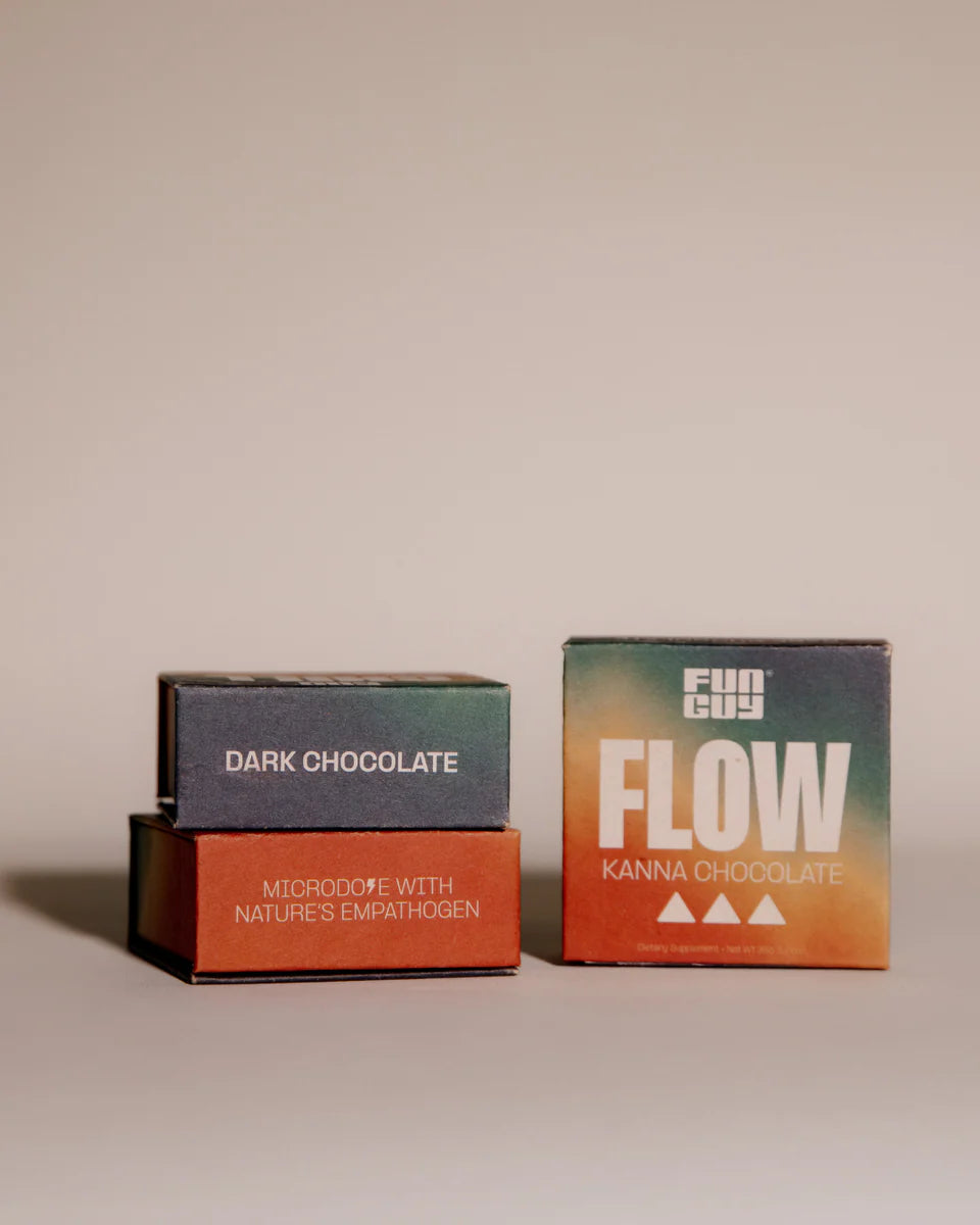 Three Fun Guy FLOW Kanna Chocolate boxes, with two stacked on the left labeled “Dark Chocolate” and “Microdose with Nature’s Empathogen,” and one box on the right showing the FLOW Kanna Chocolate front design on a neutral background.