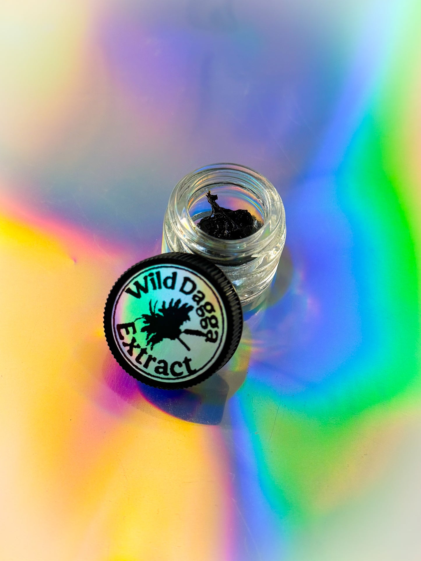 Clear Jar of 'Wild Dagga Extract' on a colorful, abstract background