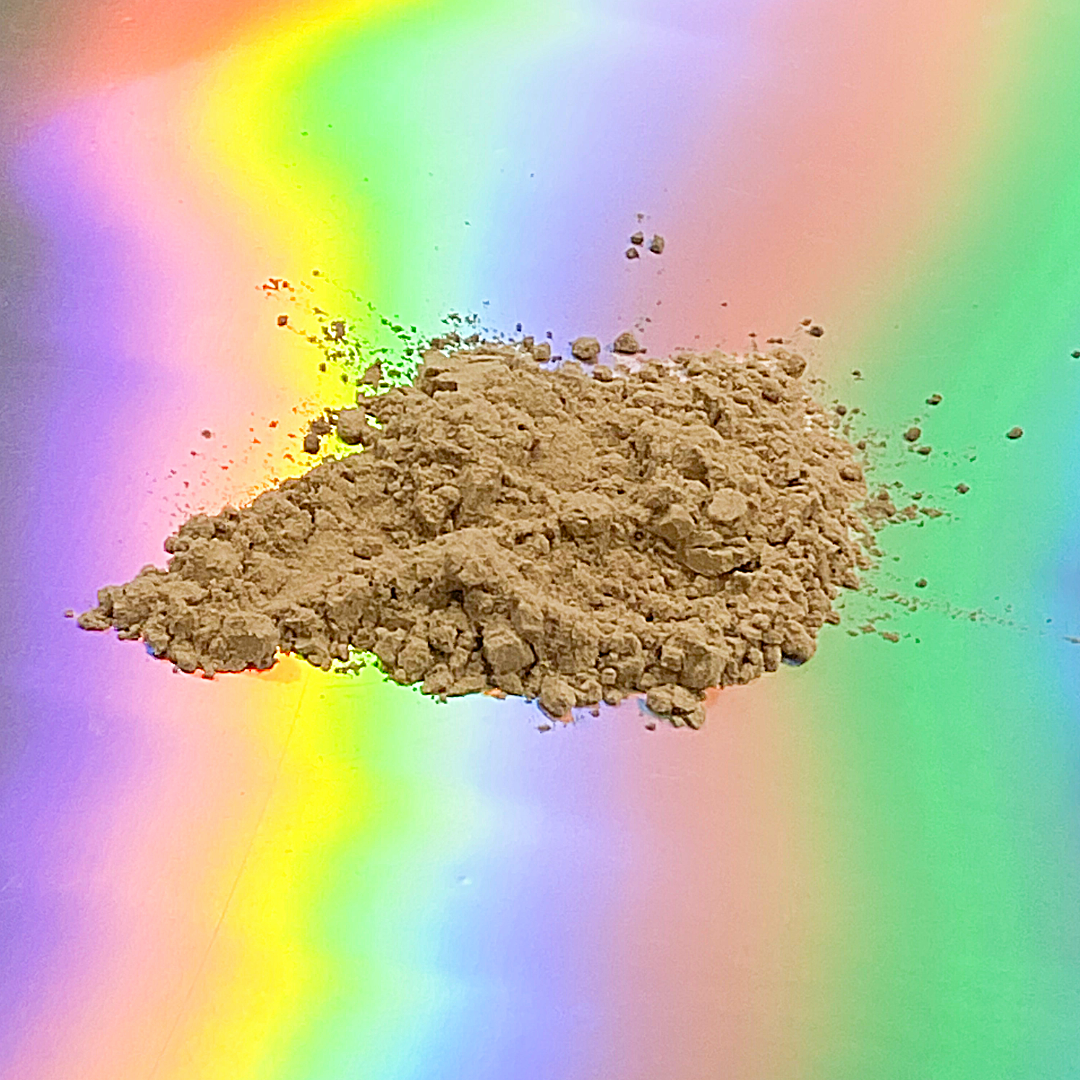 Fine instant kava powder by Healing Herbals scattered in a small mound, light tan herbal powder photographed on a vibrant iridescent rainbow gradient background.