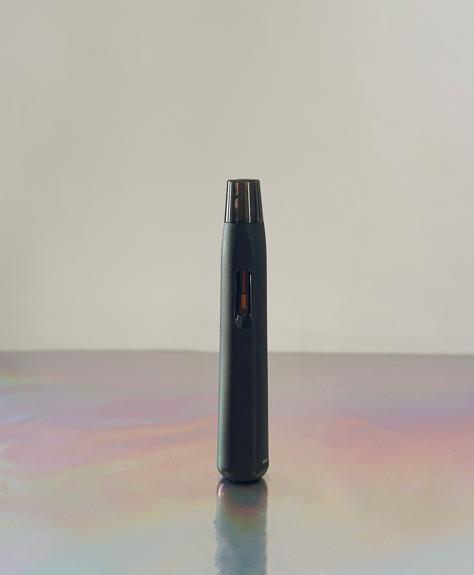 Pictured is our kanna extract vaporizer pen. Then kanna vaporizer is a slim black stick looking device. The background is grey. Made with Sceletium Tortuosum